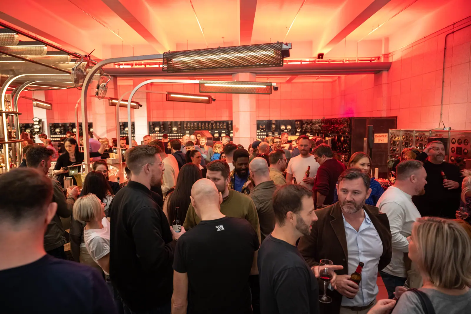 A packed launch party, lit red, with accountants and accounting-tech people talking over drinks